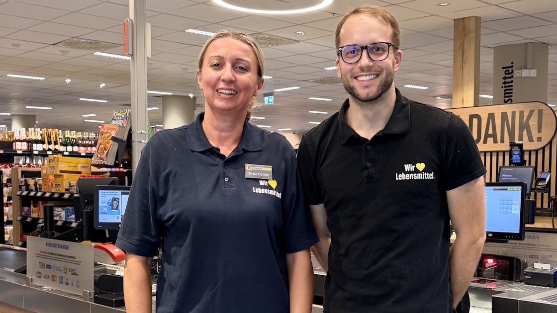 Eine Frau und ein Mann stehen in einem EDEKA-Markt vor dem Kassenbereich.