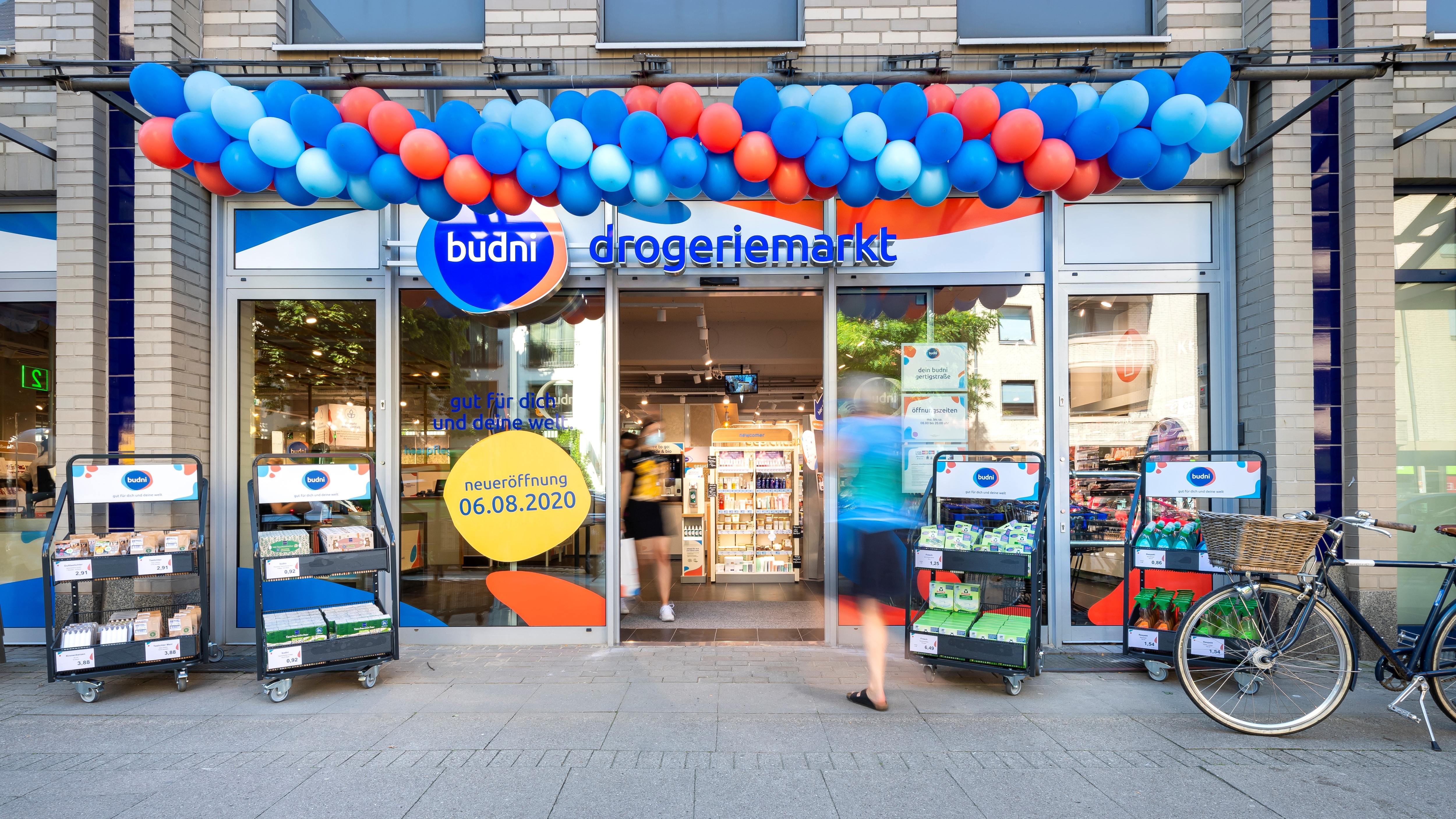 Bunte Luftballons schmücken den Eingang einer budni-Filiale