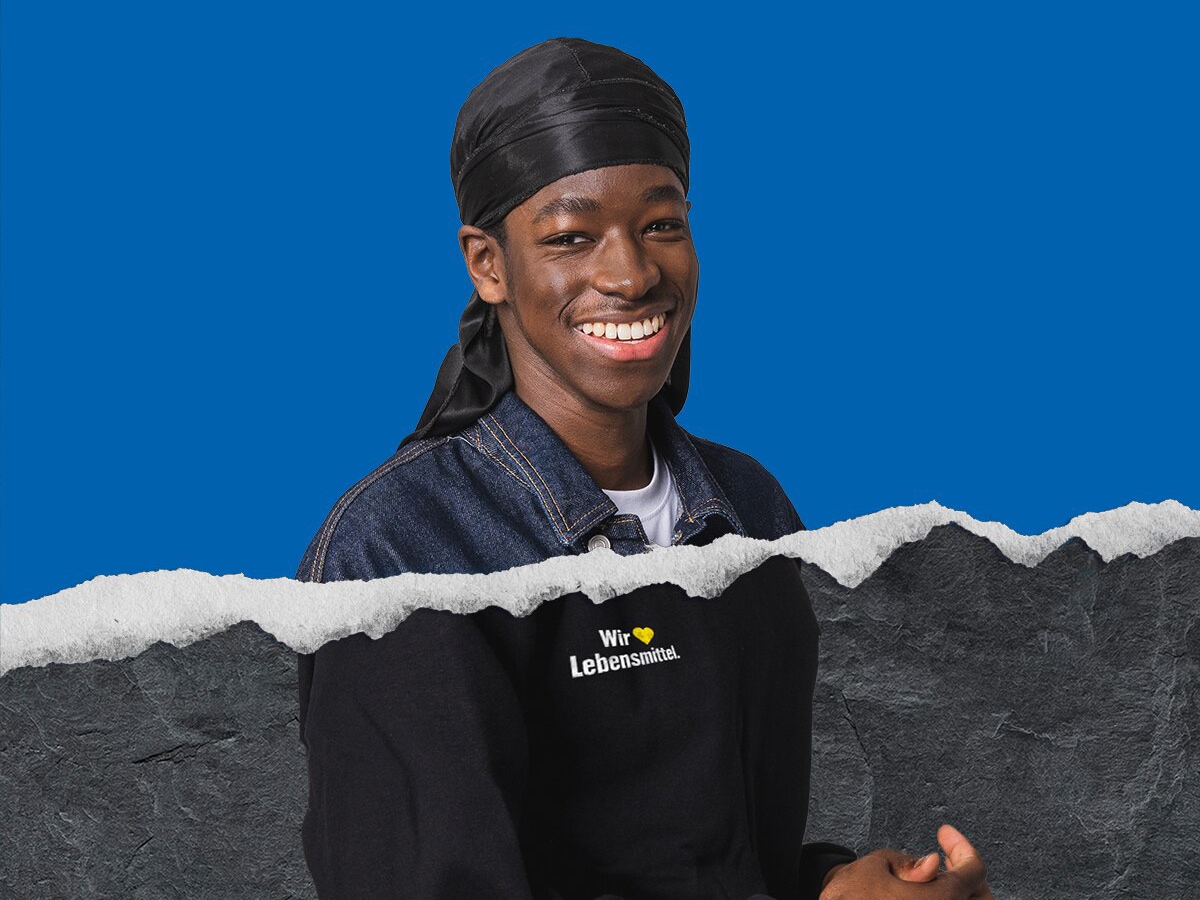 Azubi aus der Logistik vor blauem Hintergrund und Risskante