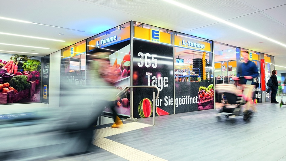 Menschen gehen am EDEKA-Markt Tamme am Flughafen in Hamburg vorbei.