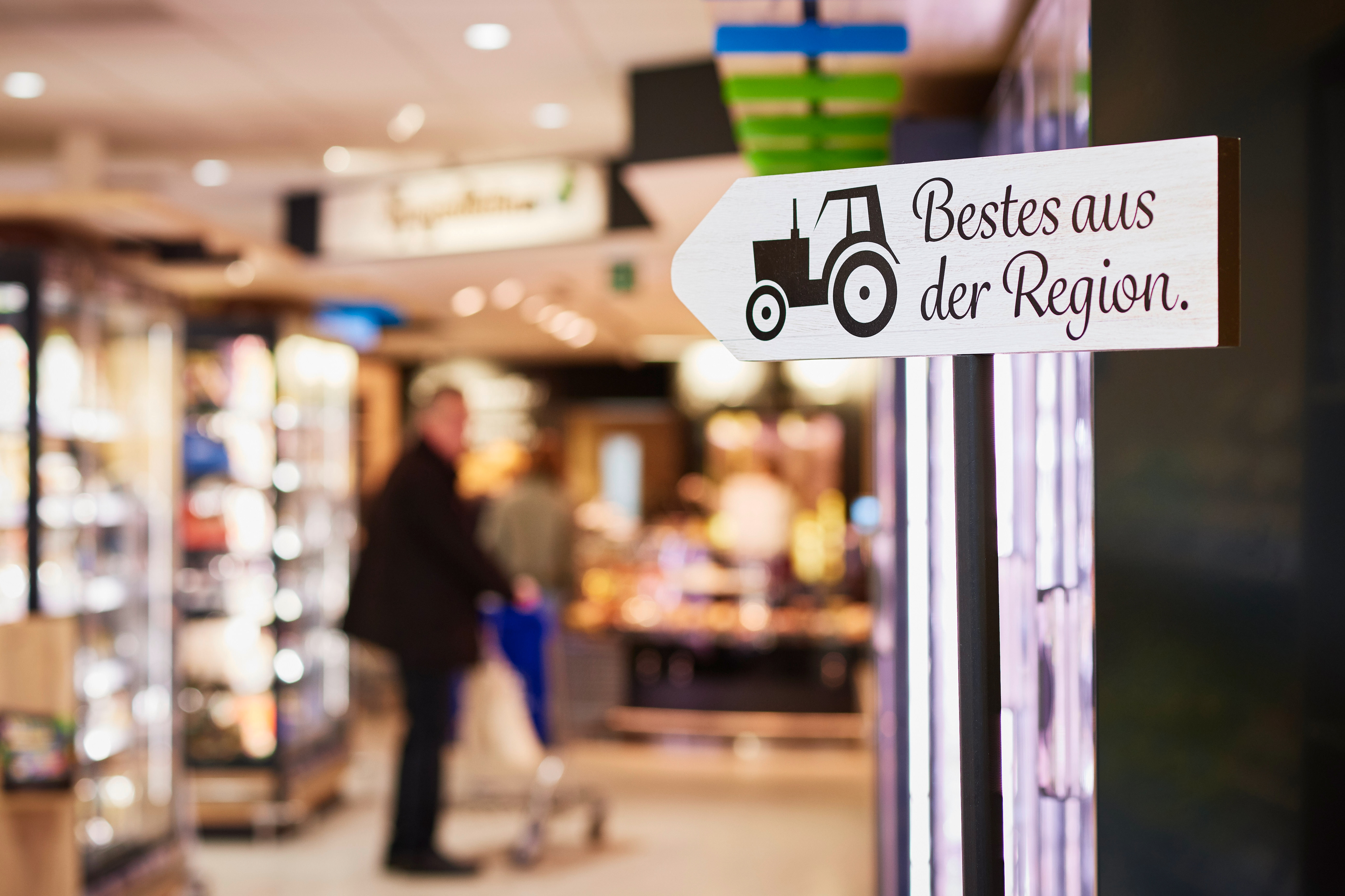 Ein Holzschild als Sortimentshinweis "Bestes aus der Region" in einem EDEKA-Markt