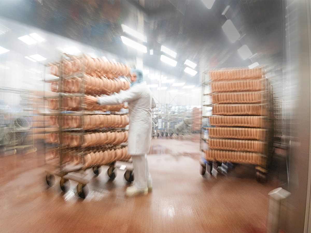 Produktionsbetrieb EDEKA Südwest Fleisch, unzählige Wiener Würstchen sind auf Rollwagen aufgehängt.  