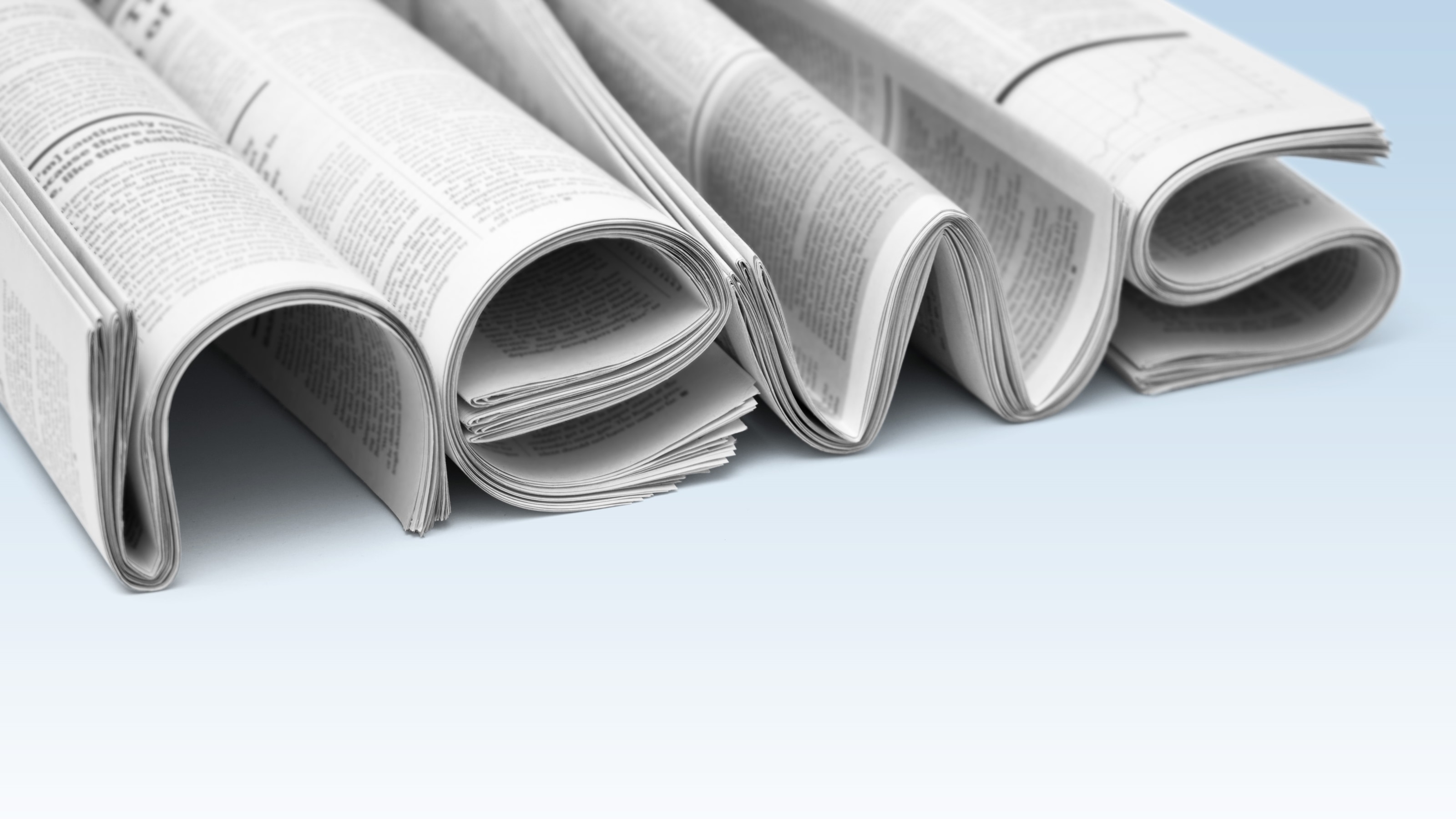 Bühnenbild der Seite: Das Wort news ist aus Zeitungen geformt.