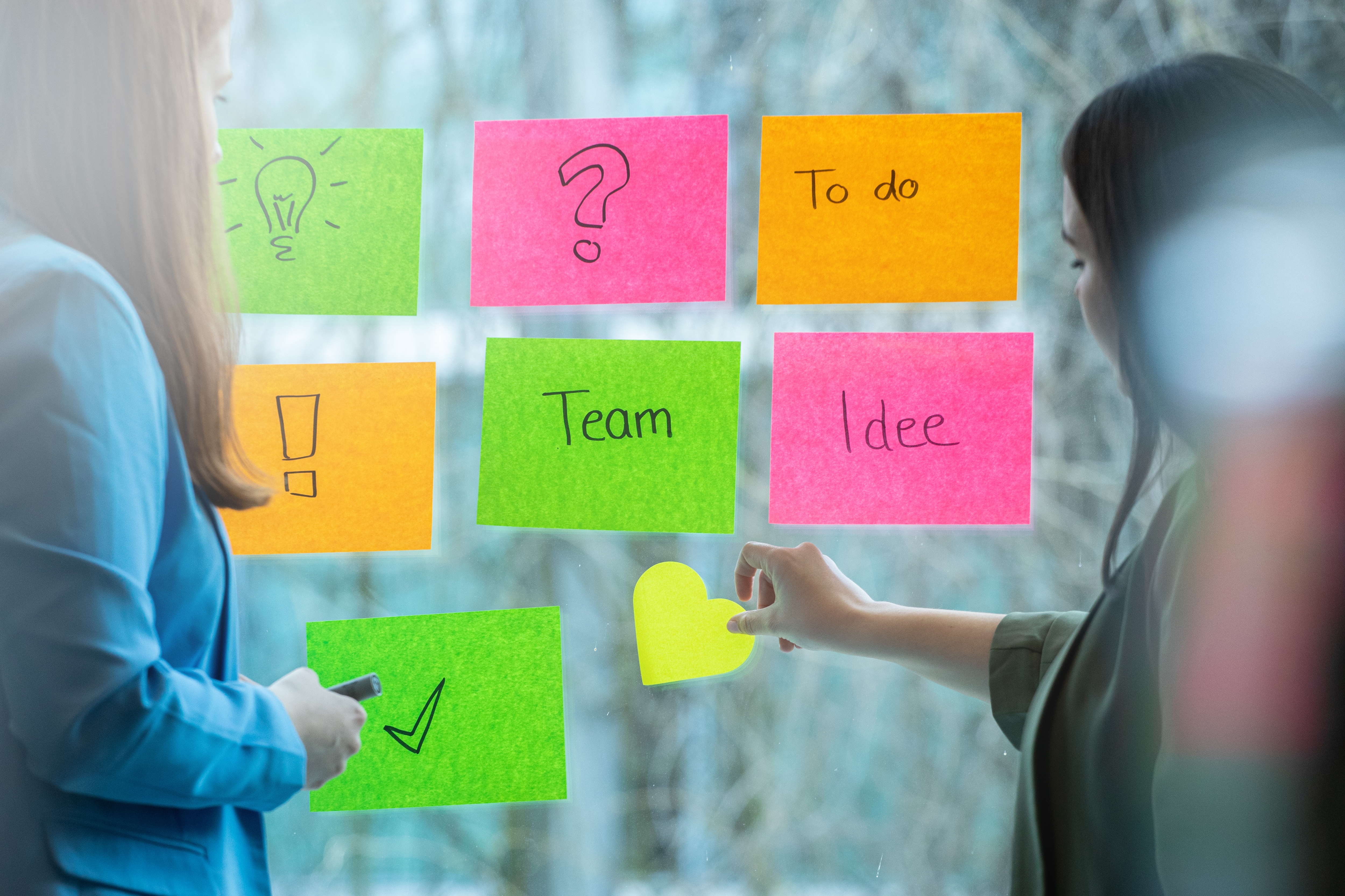 Teilnehmerinnen eines Workshops kleben Post-Its