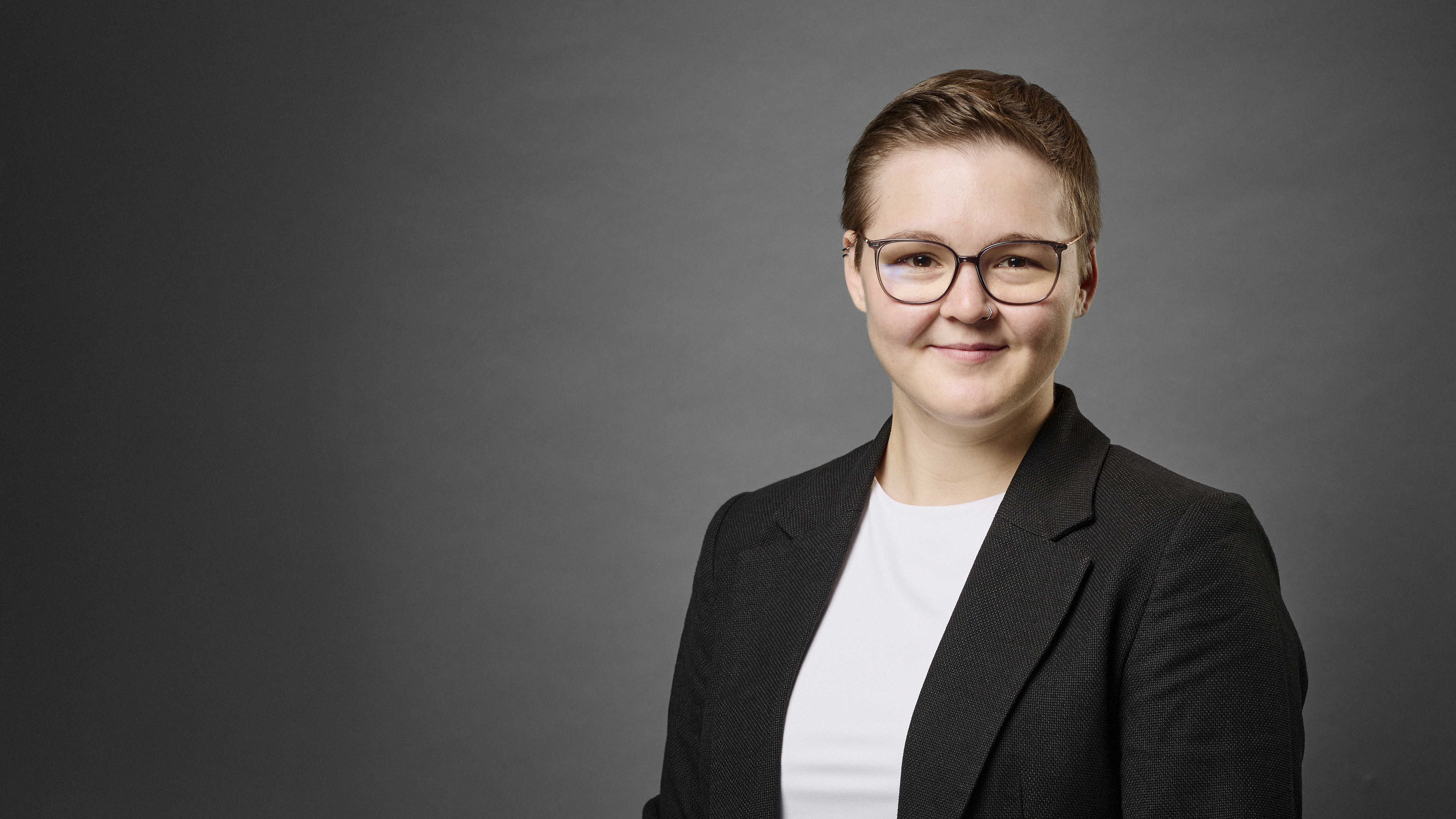 Theresa Hartenstein im Portrait vor grauem Hintergrund
